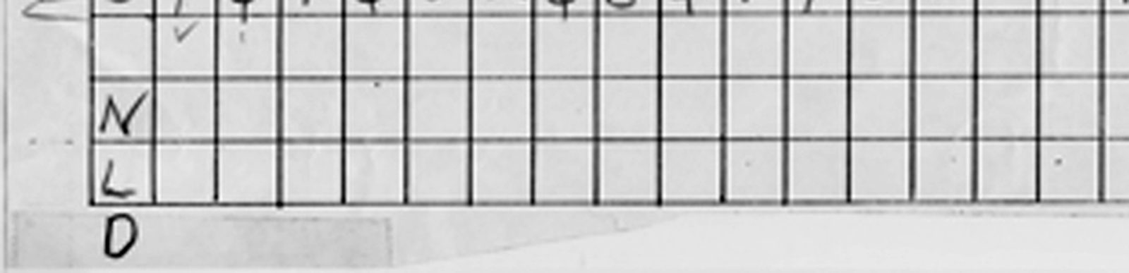 Close view of the bottom left of the K1 piece: the letters N, L and D stacked vertically in the first column of three otherwise empty grid rows, with the D sitting below the last printed rule on a strip of tape.